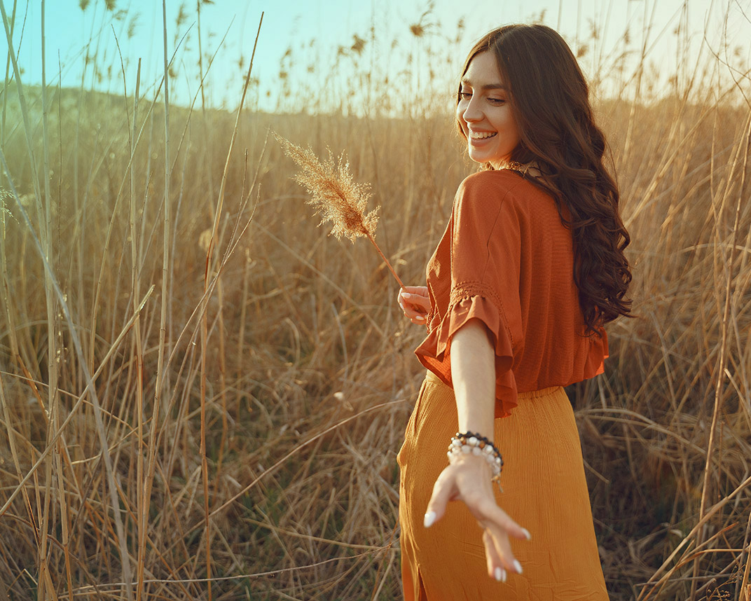 Brunette in a yellow skirt on a sunset field background