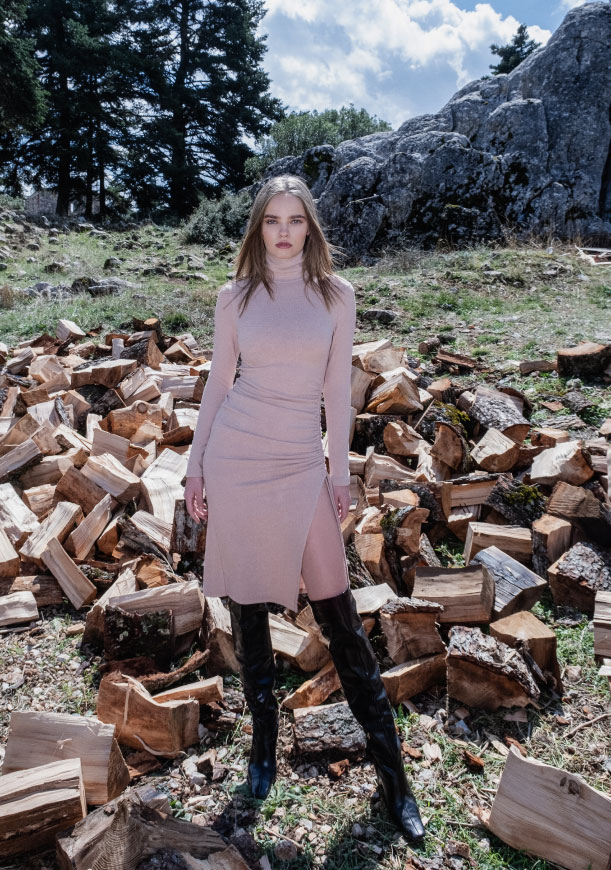 Young woman wearing a Pink Woman pale pink dress and black boots