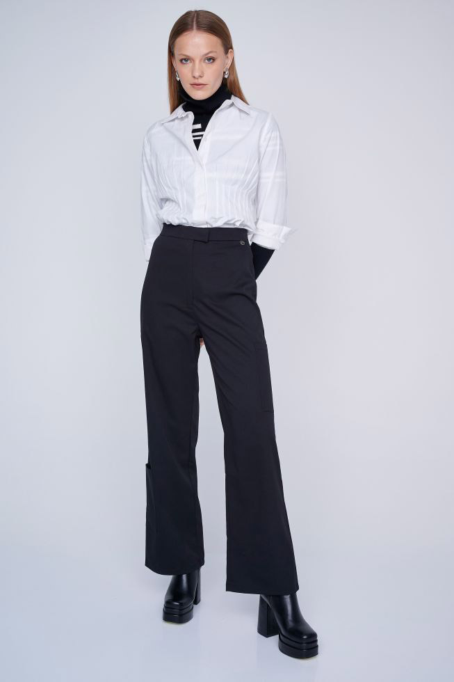 Μαύρο ζιβάγκο, λευκό πουκάμισο, μαύρο bell-bottom παντελόνι και chunky μπότες